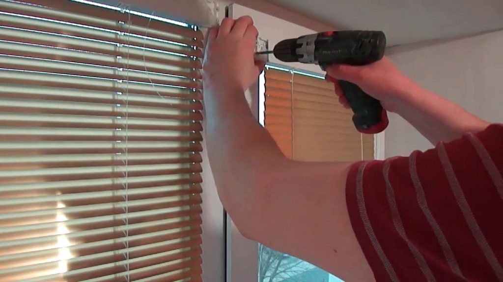 Installer expertly fitting window blinds, ensuring quality installation.